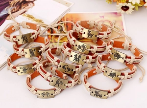 Detail of vintage bronze zodiac charms on hand-woven leather bracelets in various designs