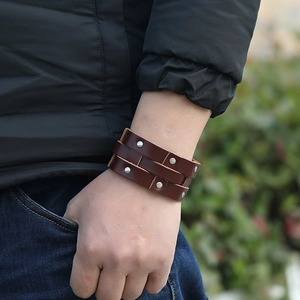 Close-up of a brown layered leather bracelet featuring silver metal rivet decorations