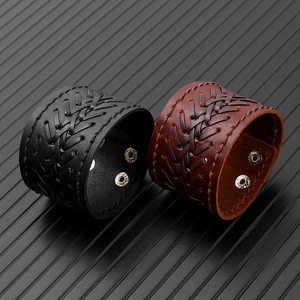 Detail of vintage woven leather bracelets in black and brown with metal snaps