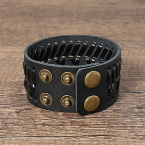 Detail of vintage braided black leather bracelet with adjustable bronze snap fasteners