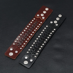 Detail of woven leather punk bracelets featuring silver metal rivets and snap buttons