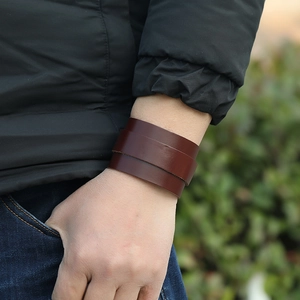 Close-up of a double-layer dark brown wide leather bracelet for men on a wrist