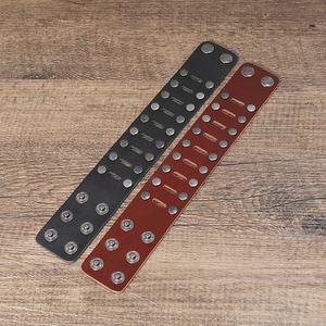 Close-up of black and brown leather bracelets with double rows of vintage metal studs