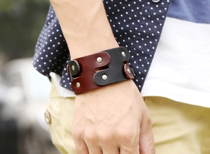 Detail of vintage punk wide leather bracelet with silver metal rivets on wrist