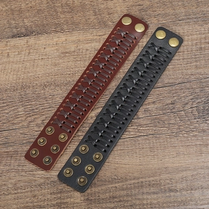 Detail of woven leather texture and double snap button closure on wide wristbands