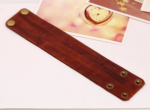 Close-up of vintage reddish brown leather bracelet with adjustable brass snap buttons