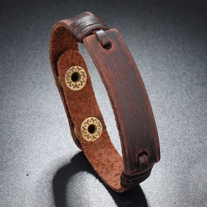 Detail of dark brown layered leather bracelet with vintage gold metal snap buttons