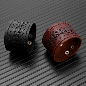 Detail of vintage braided leather bracelets with V-shape weave and metal snap buttons