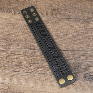 Detail of black woven leather wide bracelet with retro copper adjustable snap buttons