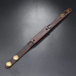 Detail of adjustable dark brown vintage leather bracelet with antique brass snap buttons