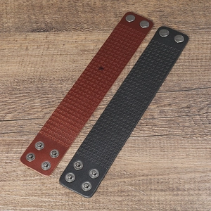 Detail of vintage leather bracelets with bow embossing and adjustable metal snaps