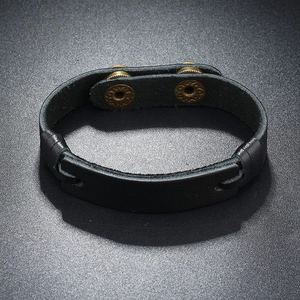 Detail view of wide black leather cuff bracelet with dual bronze metal button snaps