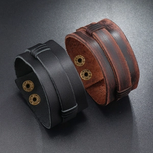 Retro punk style wide multilayer leather bracelet with dual metal snaps on black background