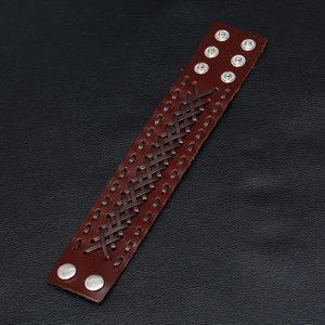 Detail of dark brown braided leather wide bracelet with adjustable silver metal snaps