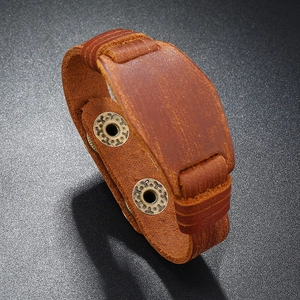 Detailed view of vintage brown leather bracelet with embossed bronze metal snap buttons