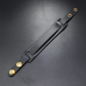 Detail of black woven leather strap featuring vintage bronze metal snap buttons and texture