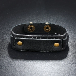 Detail of wide black leather bracelet with bronze rivets and double snap button closure