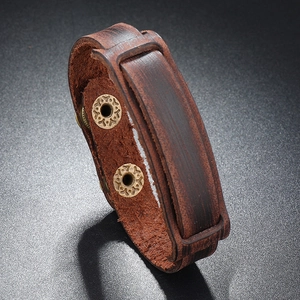 Close-up of vintage brown leather bracelet texture with engraved metal snap buttons