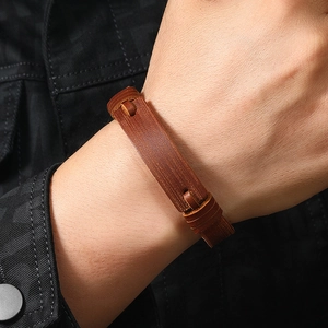 Detail of vintage brown leather bracelet texture worn with black denim jacket