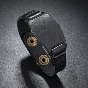 Close-up of black cowhide leather bracelet with vintage gold rivets and stitch detail