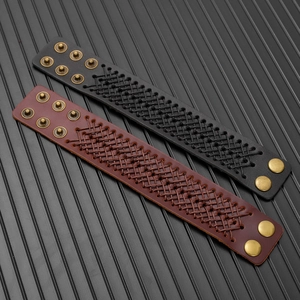 Dettaglio di bracciali vintage in pelle intrecciata con bottoni in bronzo in nero e marrone