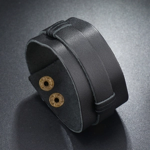 Close-up of black multilayer leather bracelet with bronze snaps and grainy texture