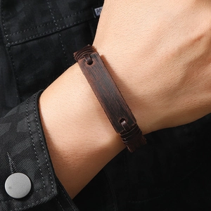Detail of dark brown vintage leather cuff bracelet with rustic wood-like texture on model