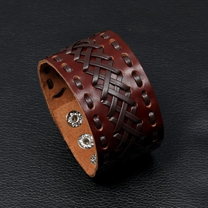 Macro detail of dark brown woven leather bracelet with adjustable metal snap buttons