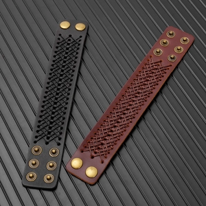 Dettaglio di bracciali vintage in pelle intrecciata con bottoni a pressione in bronzo