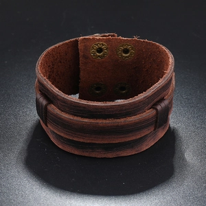 Macro shot of dark brown multi-layer leather bracelet with bronze metal buttons