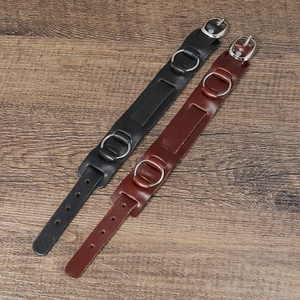 Dettaglio di bracciali punk in pelle multistrato con fibbie metalliche e anelli a O