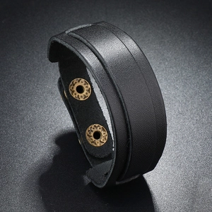 Detailed macro view of the double-layered black leather texture and vintage copper snaps