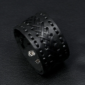 Detail of wide black woven leather bracelet with punk style silver metal snap buttons