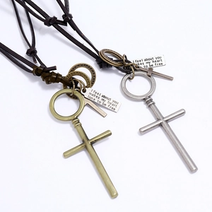 Dettaglio di ciondoli a croce vintage in bronzo e argento con cordini in pelle marrone