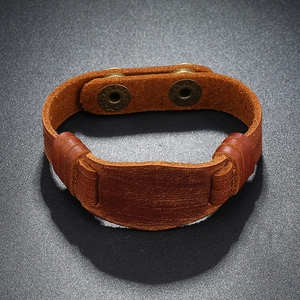 Detail of brown genuine leather bracelet featuring adjustable vintage bronze metal snaps