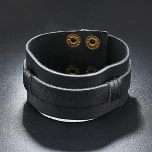 Detail of vintage wide black leather wristband with bronze snap buttons and stitching