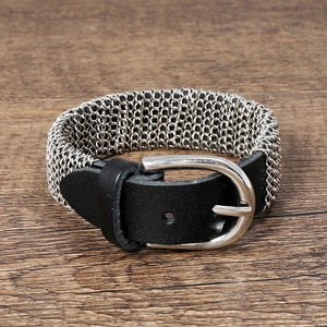 Detail of punk silver chain mesh bracelet with black leather strap and metal buckle