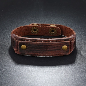 Detail of vintage brown leather bracelet featuring brass sun-patterned snap buttons