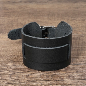 Gros plan sur un bracelet punk en cuir noir mat avec boucle réglable en métal