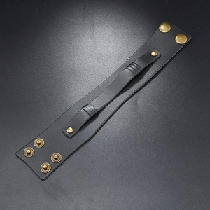 Detail of vintage black multilayer leather wristband with adjustable brass snap buttons