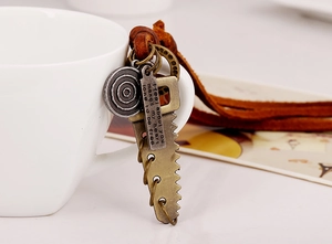 Macro view of vintage leather necklace with antique saw and engraved plaque pendants