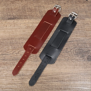 Gros plan de larges bracelets rétro en cuir noir et marron avec boucles en métal