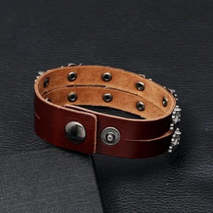 Detail view of double-row silver skull studs on premium dark brown leather punk bracelet