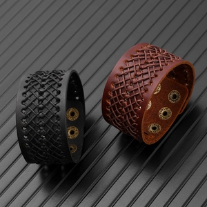 Dettaglio di bracciali larghi in pelle intrecciata con cinturini e bottoni automatici