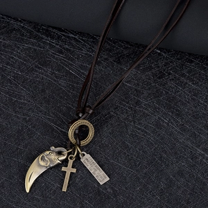 Détail du collier en cuir vintage avec éléphant en bronze, croix et plaque gravée