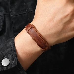 Close-up of wide retro dark brown leather bracelet with detailed stitching on sleeve