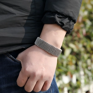 Close-up of a punk-style silver metal mesh chain bracelet worn on a wrist