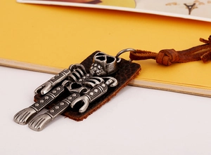 Detail of vintage skull pendant featuring antique alloy finish and brown leather cord