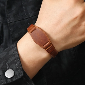Detail of vintage brown leather bracelet with reinforced stitching on a male wrist