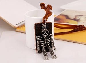 Macro shot of industrial punk skull robot pendant on dark brown genuine leather base